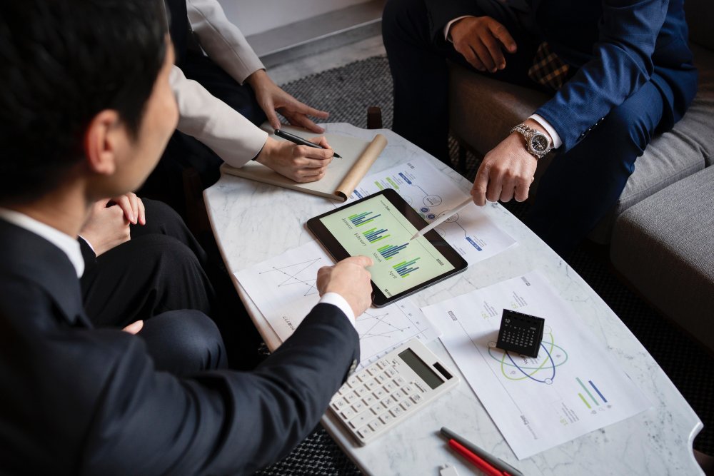 Business professionals reviewing financial charts and tablet data during strategy meeting.